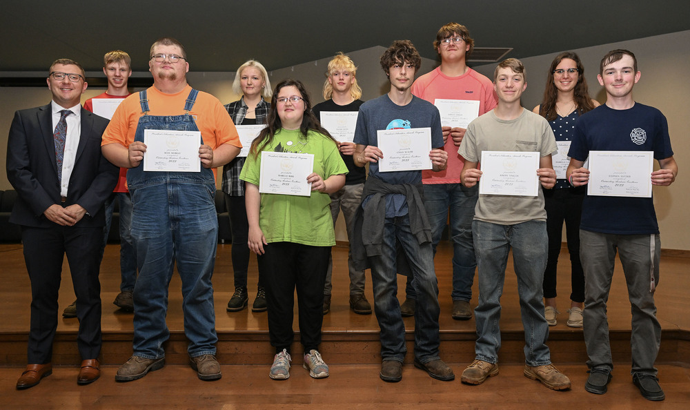 Junior CTE students on stage holding awards