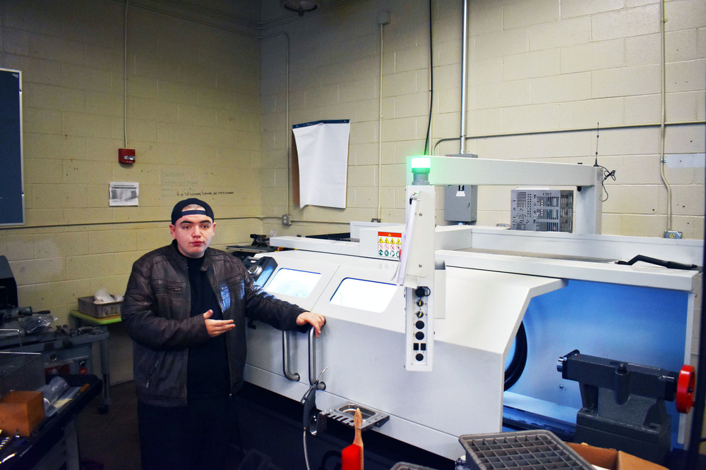 Student standing by CNC lathe in Advanced Manufacturing