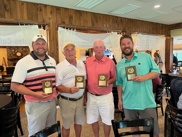 Team Dangle members pose with plaques from 2022 golf tournament
