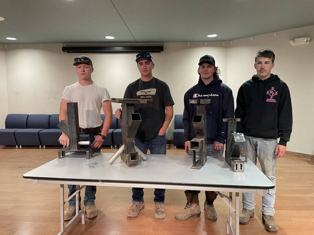 Four Welding students posing with rocket stove projects