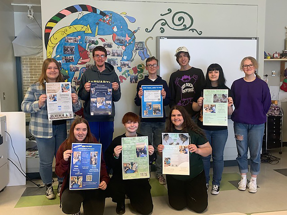Visual Communications students hold the posters they made for the LPN program