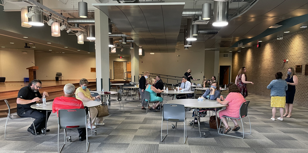 People sitting at tables in WEB Complex lobby for retirees and tenure Board of Educaiton reception
