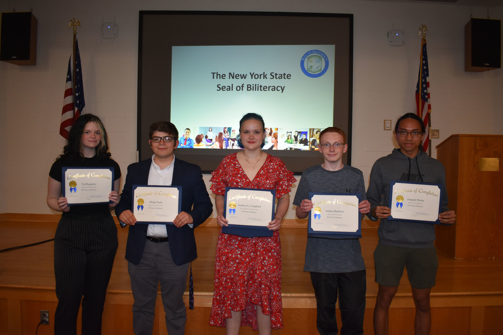 Five Seal of Biliteracy recipients hold up their certificates