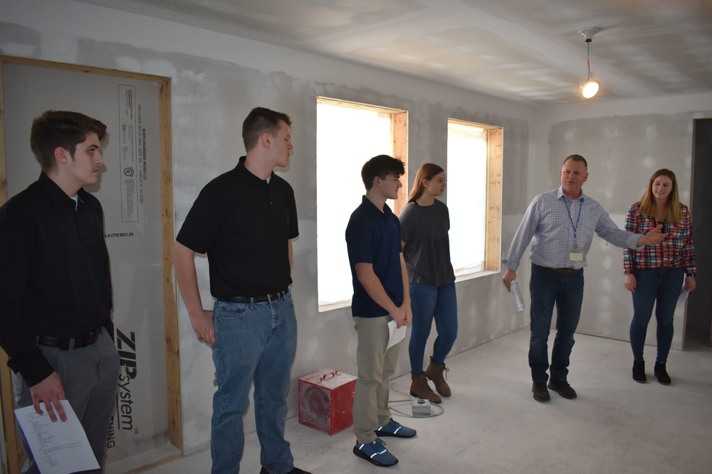 Building construction teachers and students giving house tour