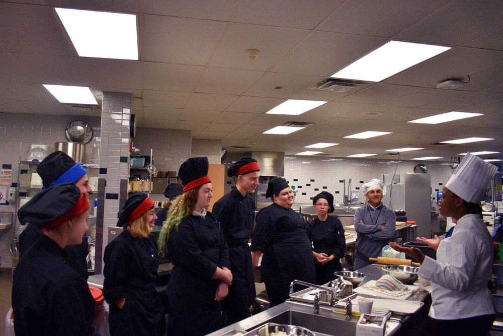Culinary Institute of America chef speaks in kitchen to Herkimer BOCES culinary students and instructor