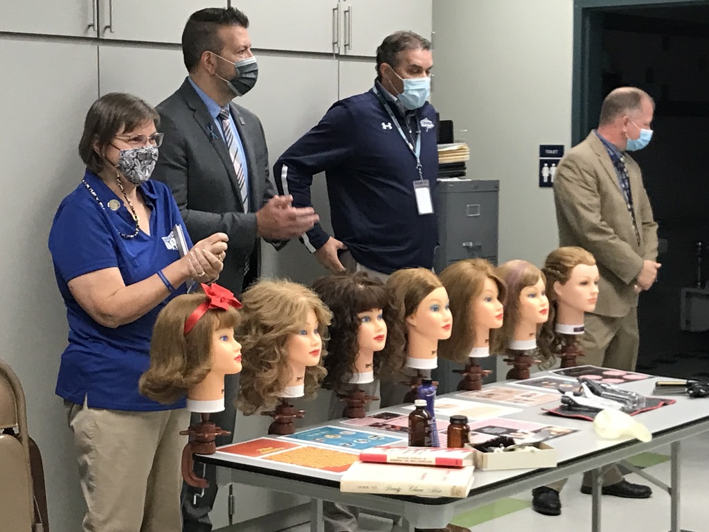 Sandy Sherwood and component superintendents view a cosmetology presentation