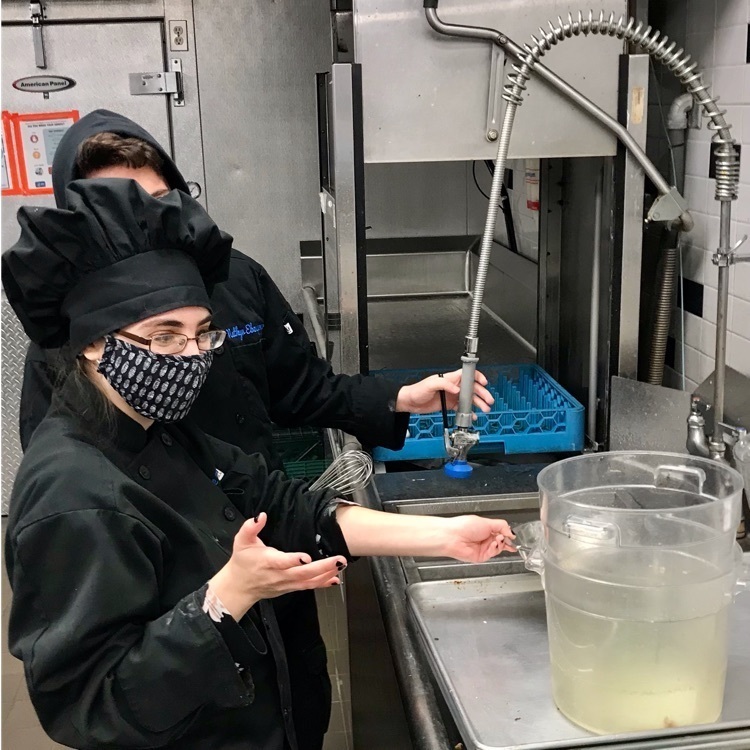 Two Culinary students cleaning up