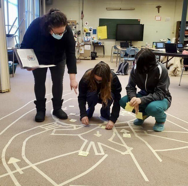 Instructor and two students using floor heart model