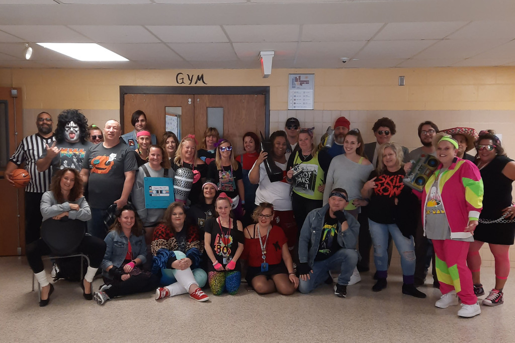 A group of Pathways Academy staff members in 80s gear for Halloween