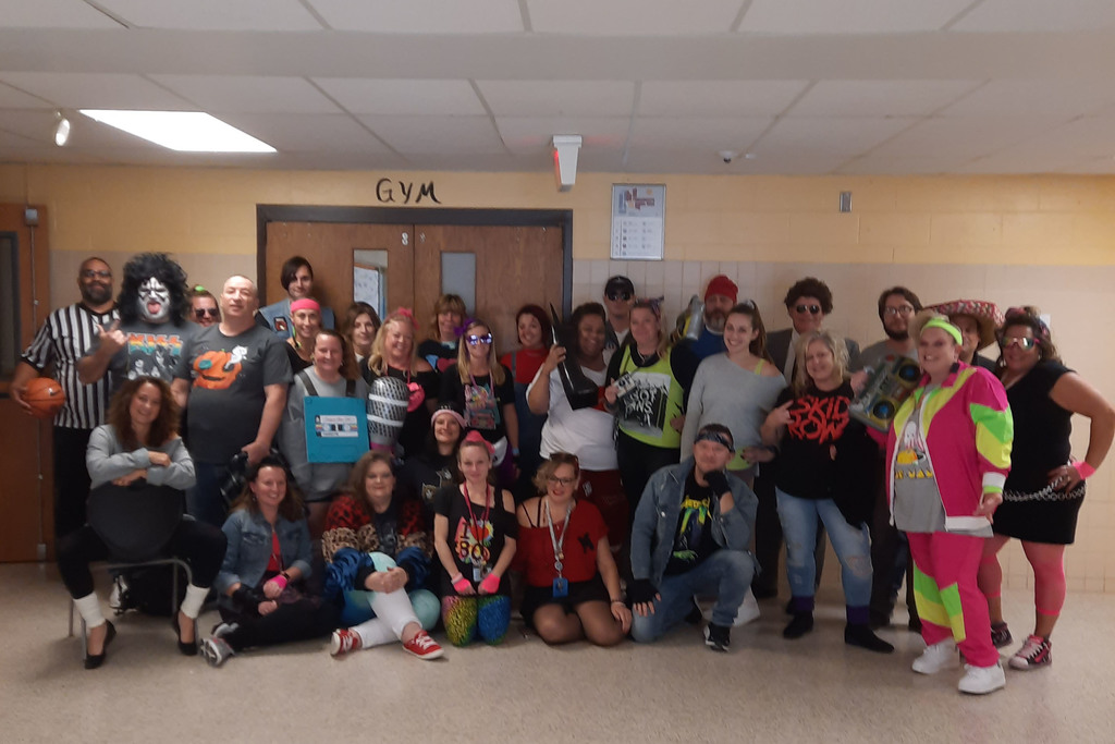 A group of Pathways Academy staff members in 80s gear for Halloween