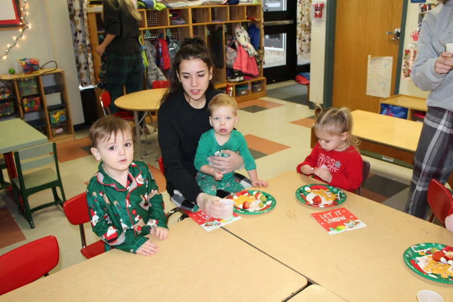 Child and Family Services student sitting with three Toddler Play Group children