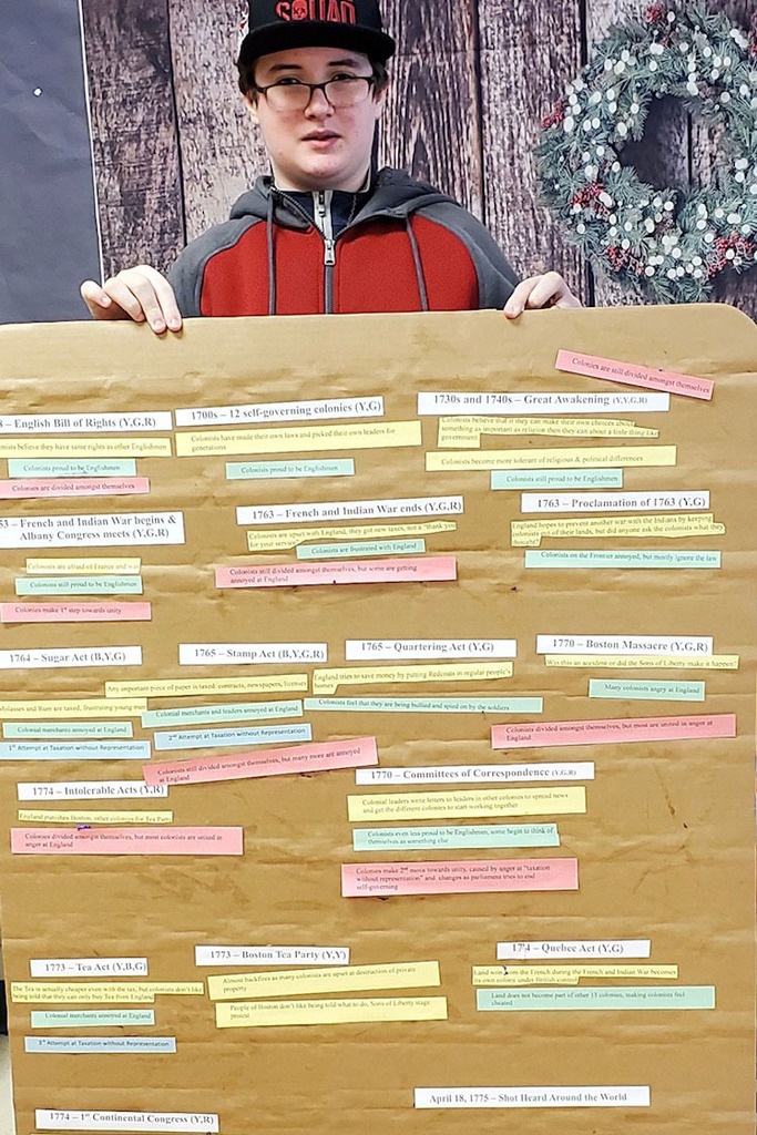 Student holding up social studies project