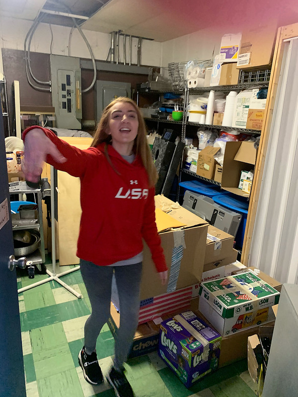 Student Zoe Randall standing by boxes of donations she delivered at the Mohawk American Legion 