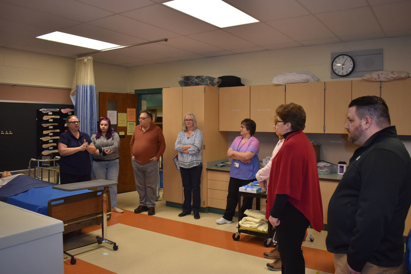 LPN instructor and a Pathways student talking to tour guests in nursing lab 