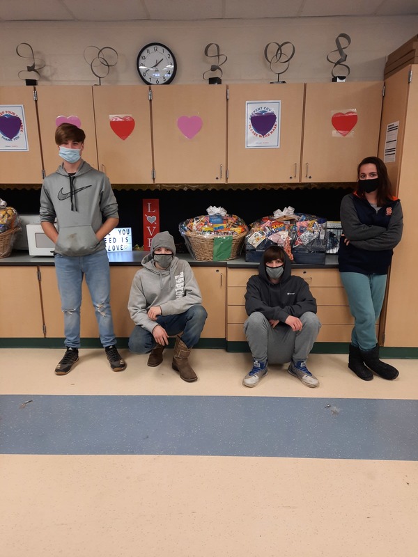 Four students with two goodie baskets in a classroom