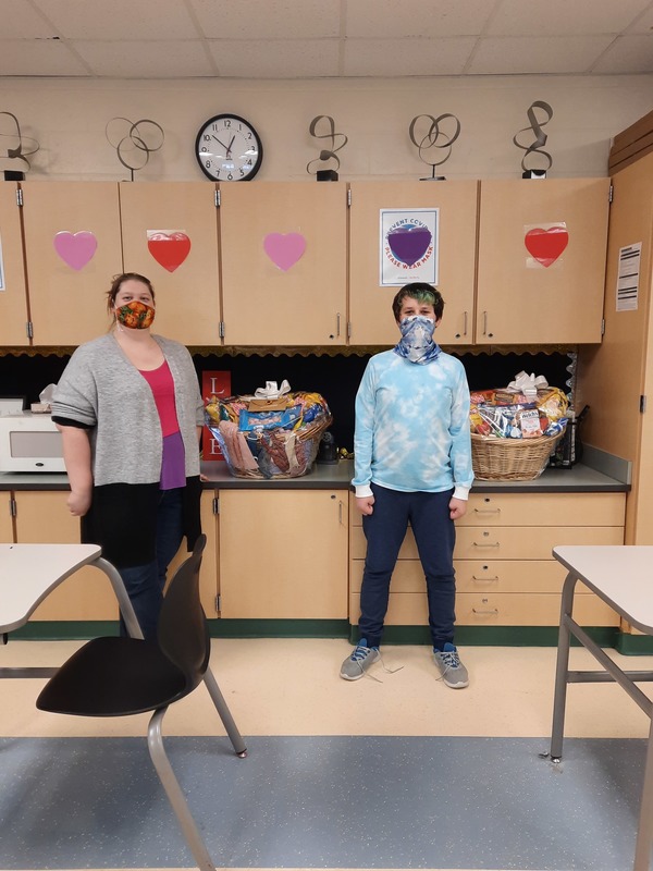 A teacher and a student with two goodie baskets in a classroom