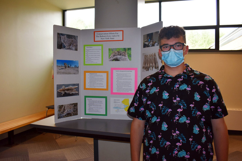 Conservation student Alex Scholl poses next to his project