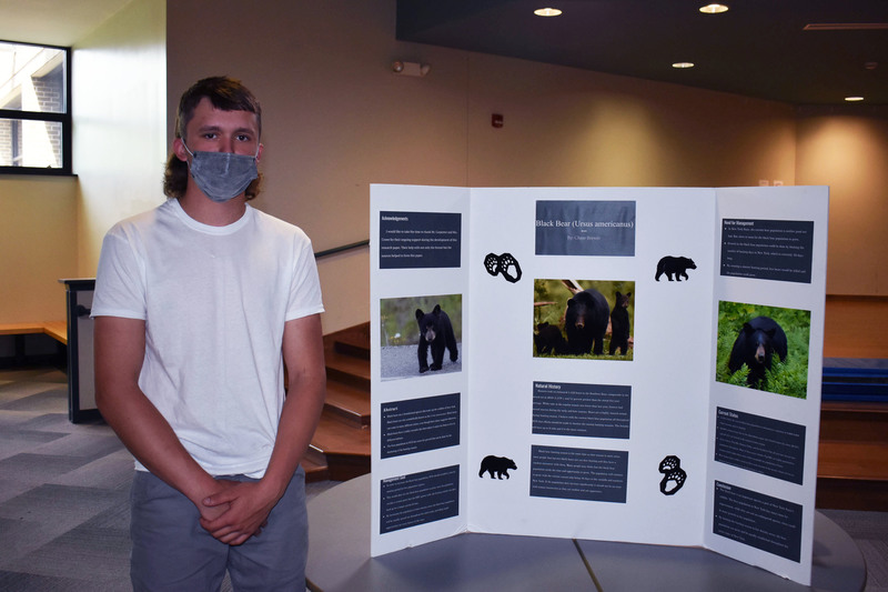 Conservation student Chase Brewer poses next to his project