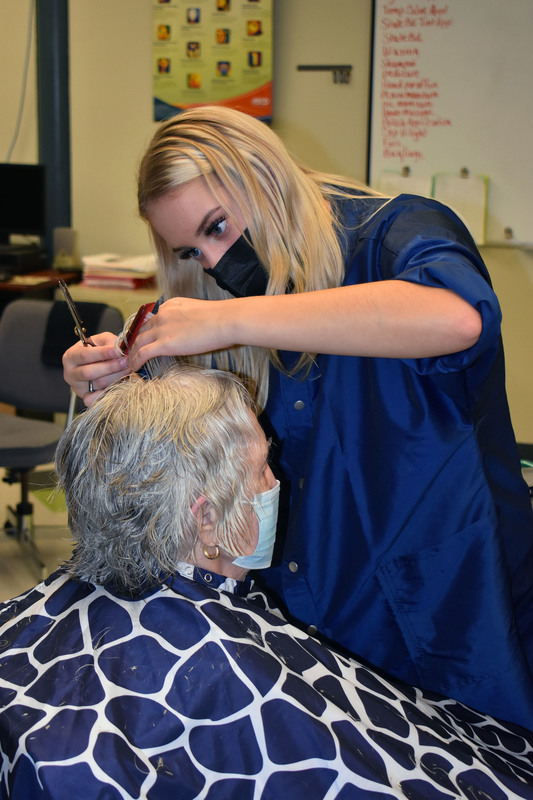 Cosmetology student gives a haircut to Herkimer resident