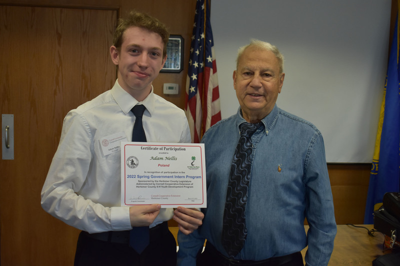 Student Adam Nellis poses with certificate and Legislator Peter Mano in Herkimer County legislative chambers