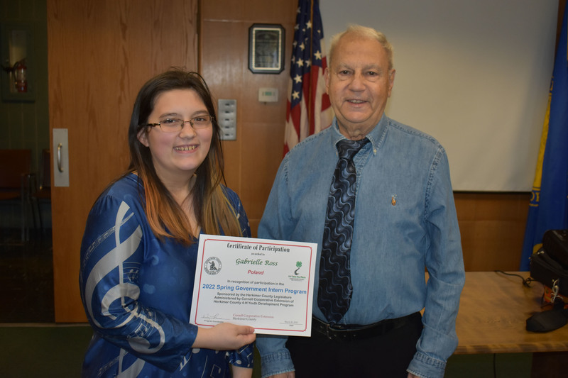 Student Gabrielle Ross poses with certificate and Legislator Peter Mano in Herkimer County legislative chambers
