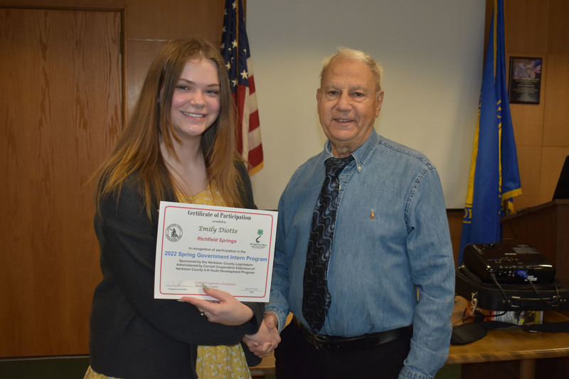 Student Emily Diotte poses with certificate and Legislator Peter Mano in Herkimer County legislative chambers
