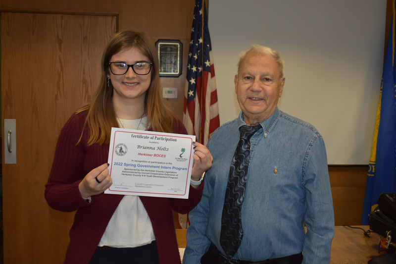 Student Brianna Holtz poses with certificate and Legislator Peter Mano in Herkimer County legislative chambers