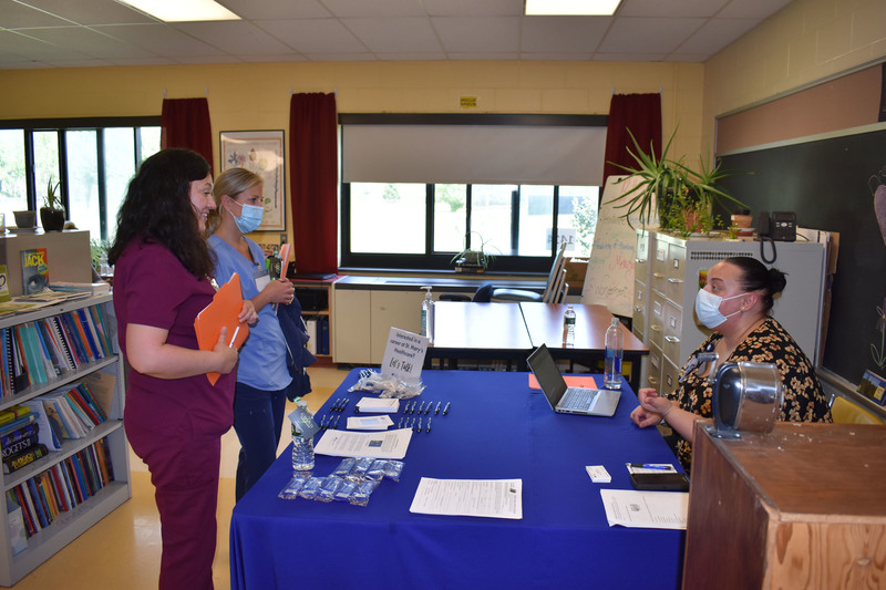 Two LPN students talking to a St. Mary's representative