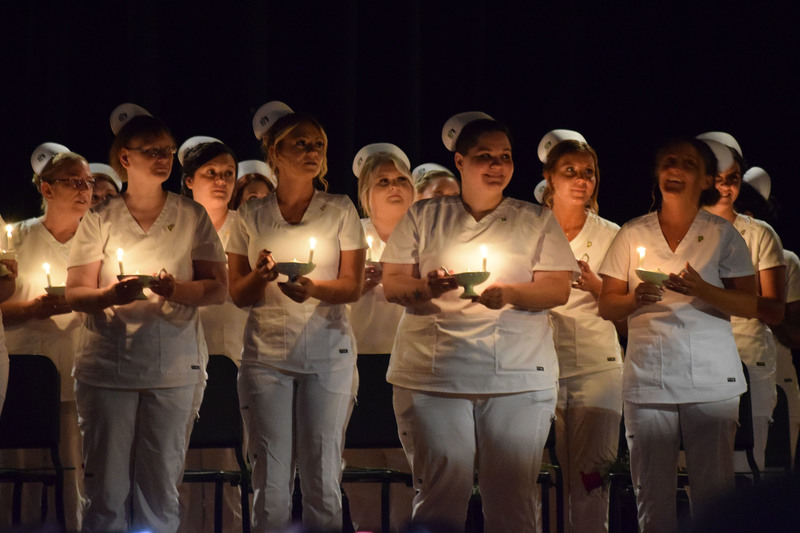 LPN students holding candles on stage