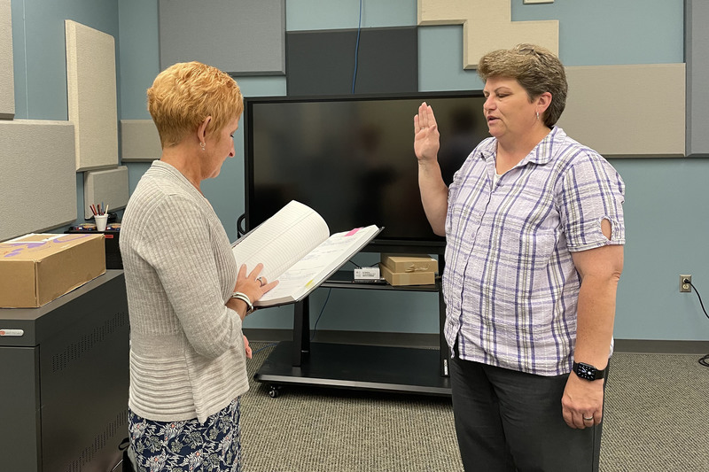 Janine Lynch getting sworn in as board member by Board Clerk Shawn Maxson after being re-elected to the board