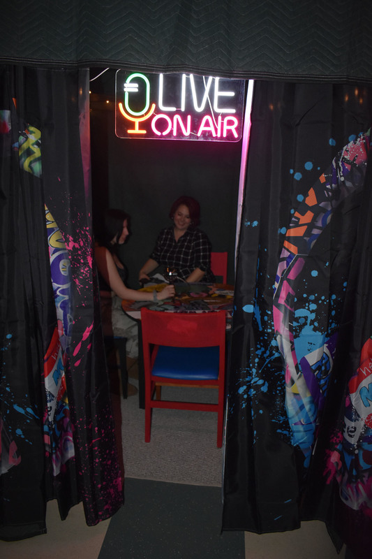 A Pathways Academy student and English teacher in podcast recording booth with a sign that says "Live On Air"