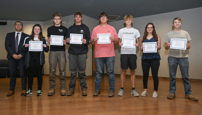 Junior CTE students on stage holding awards