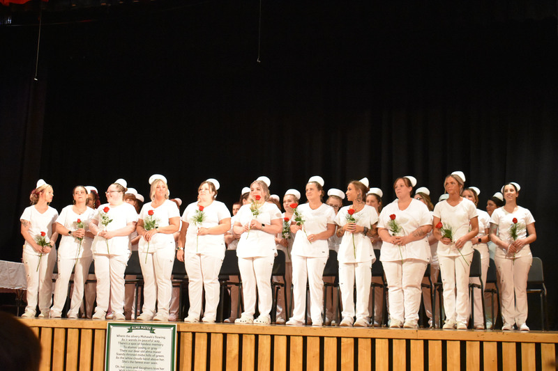 Adult LPN students standing on stage