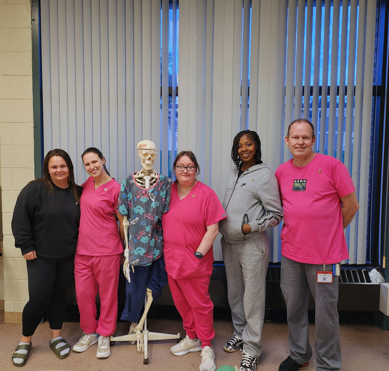 Five adult CNA students pose for a photo