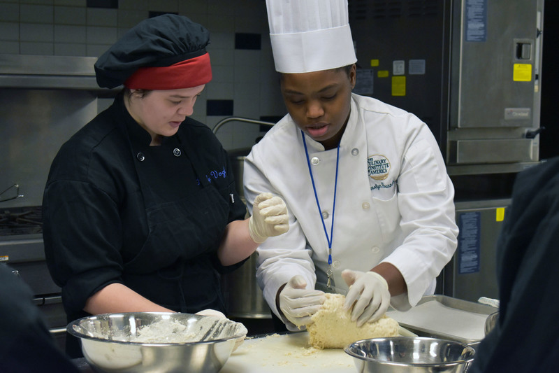 Culinary Institute of America chef shows culinary student how to make dough for naan